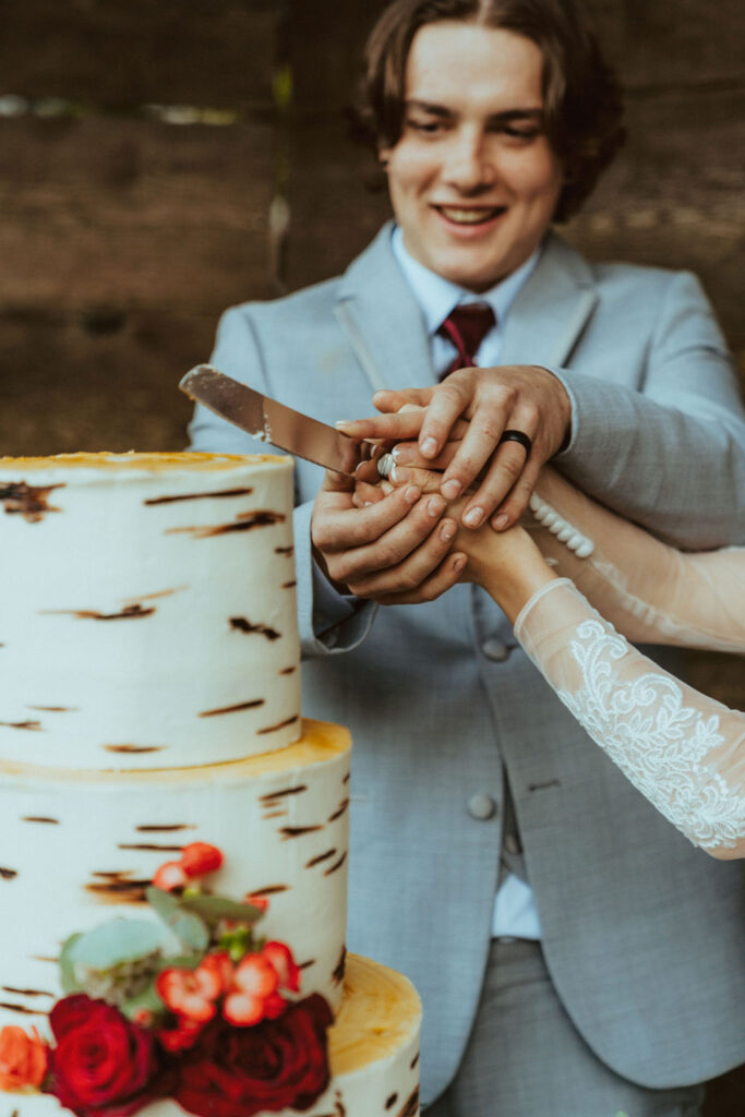 rustic fall wedding cake being cut by the bride and groomcelebrating love surrounded by fall foliage and the beautiful Oregon riverside. 