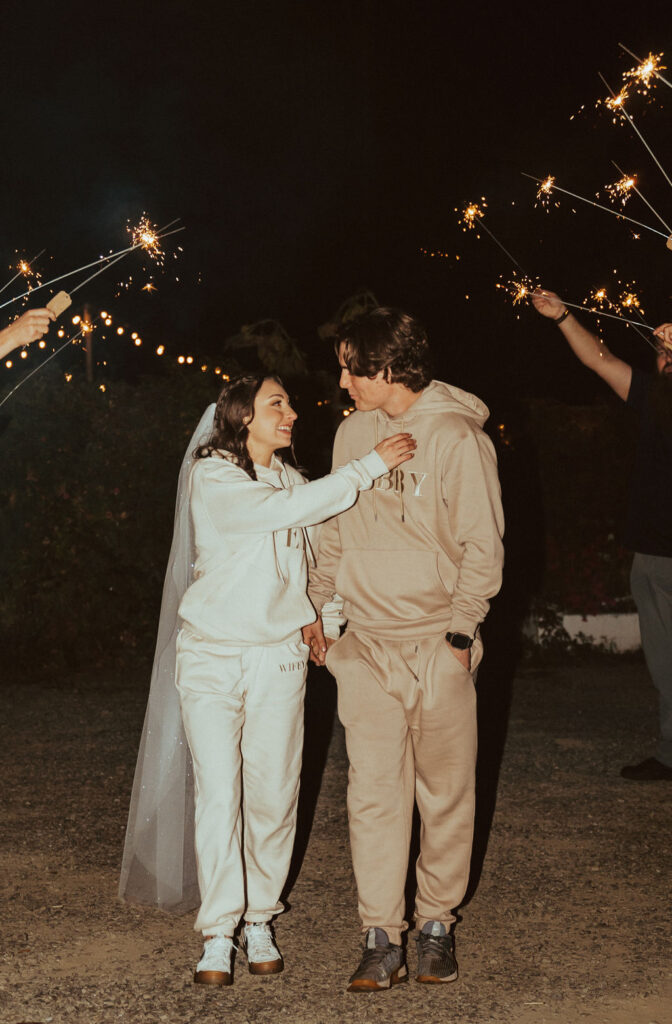sparkler wedding exit with bride and groom in their wifey and hubby wedding sweat suits during the fall 