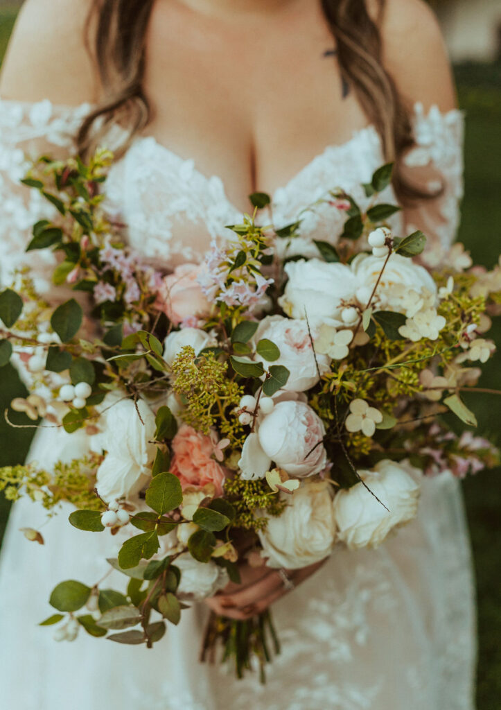 floral arrangement with bride holding flowers
