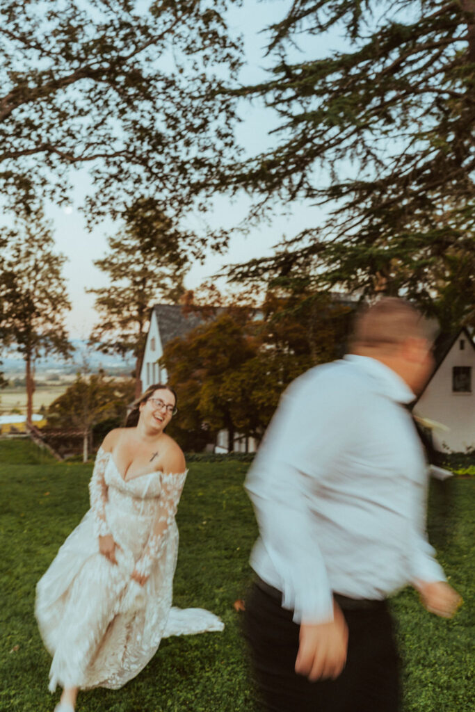 bride chasing groom while laughing in her wedding dress