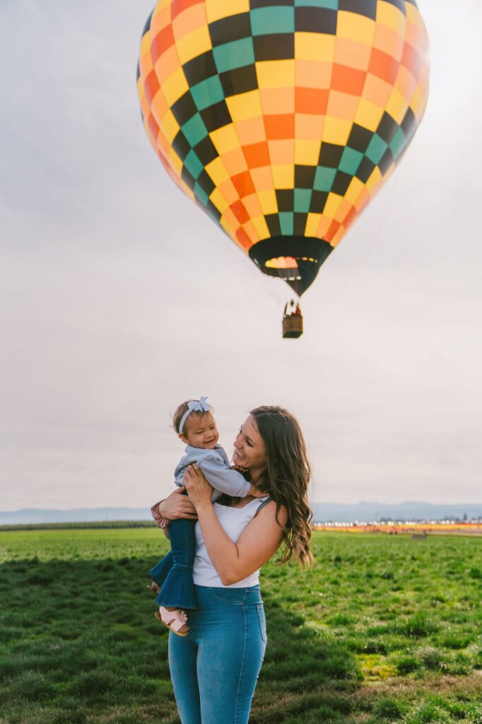 mom smiling at daughter in front of hot hair ballon