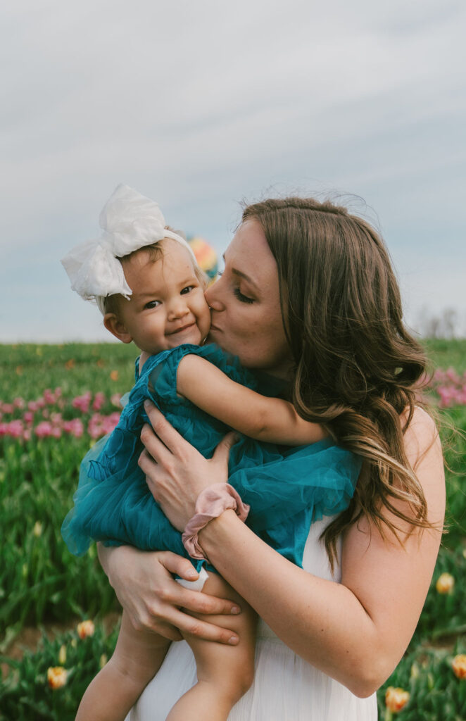 mommy and me photoshoot of mom kissing daughter