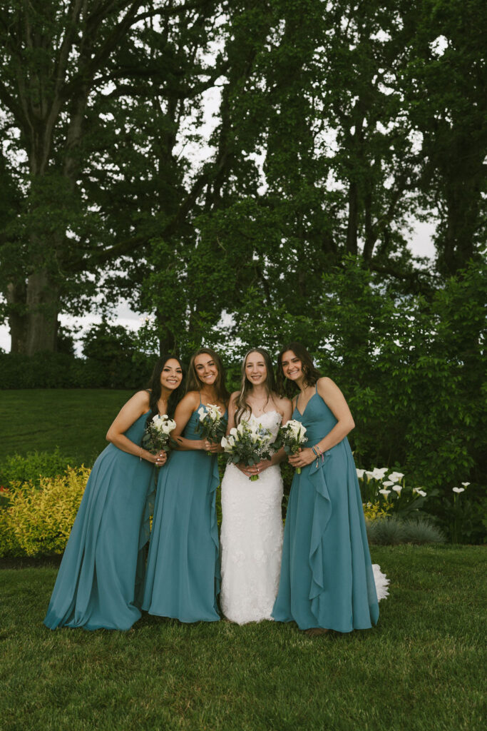 bride with her bridesmaids in teal blue dresses