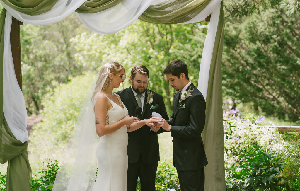 bride and groom on a spring wedding exchanging rings