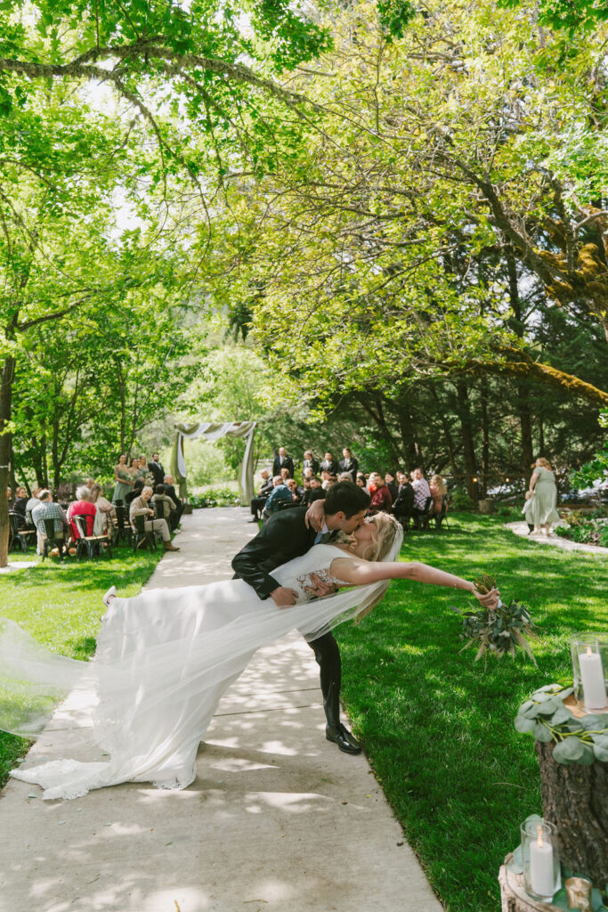 bride and groom kissing at the end of walking down the isle